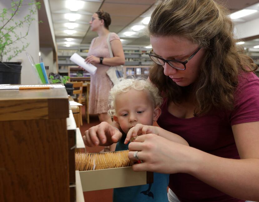 Roland Upchurch, 2, and Jeneva Upchurch browse the new seed library program at the Dallas...