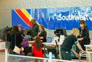 Southwest Airlines employees help travelers at Dallas Love Field Airport, Wednesday, Nov....