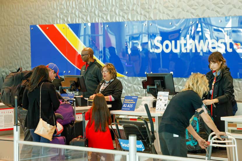 Southwest Airlines employees help travelers at Dallas Love Field Airport on Nov. 22 in Dallas.