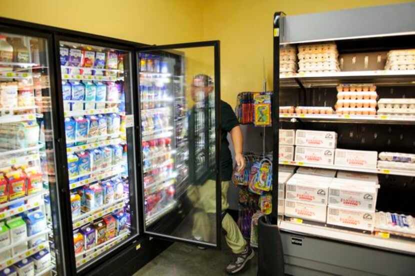 
Orlando Guajardo rearranges items in the display refrigerators at the Wal-Mart store off...
