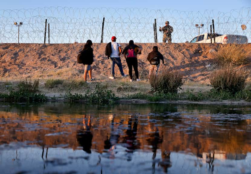 A migrant family listened to instruction from a guardsman as they looked for a way through...