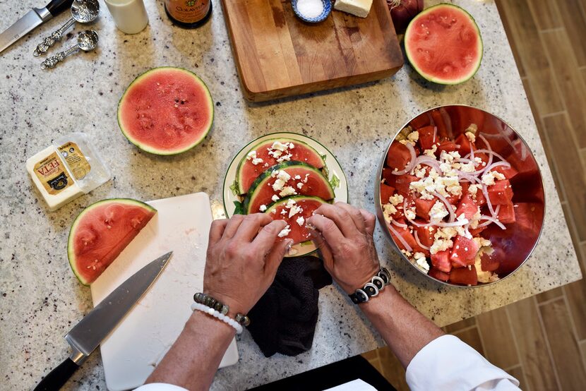 John Lymberopoulos, executive chef for the Greek Food Festival, places feta cheese crumbles...