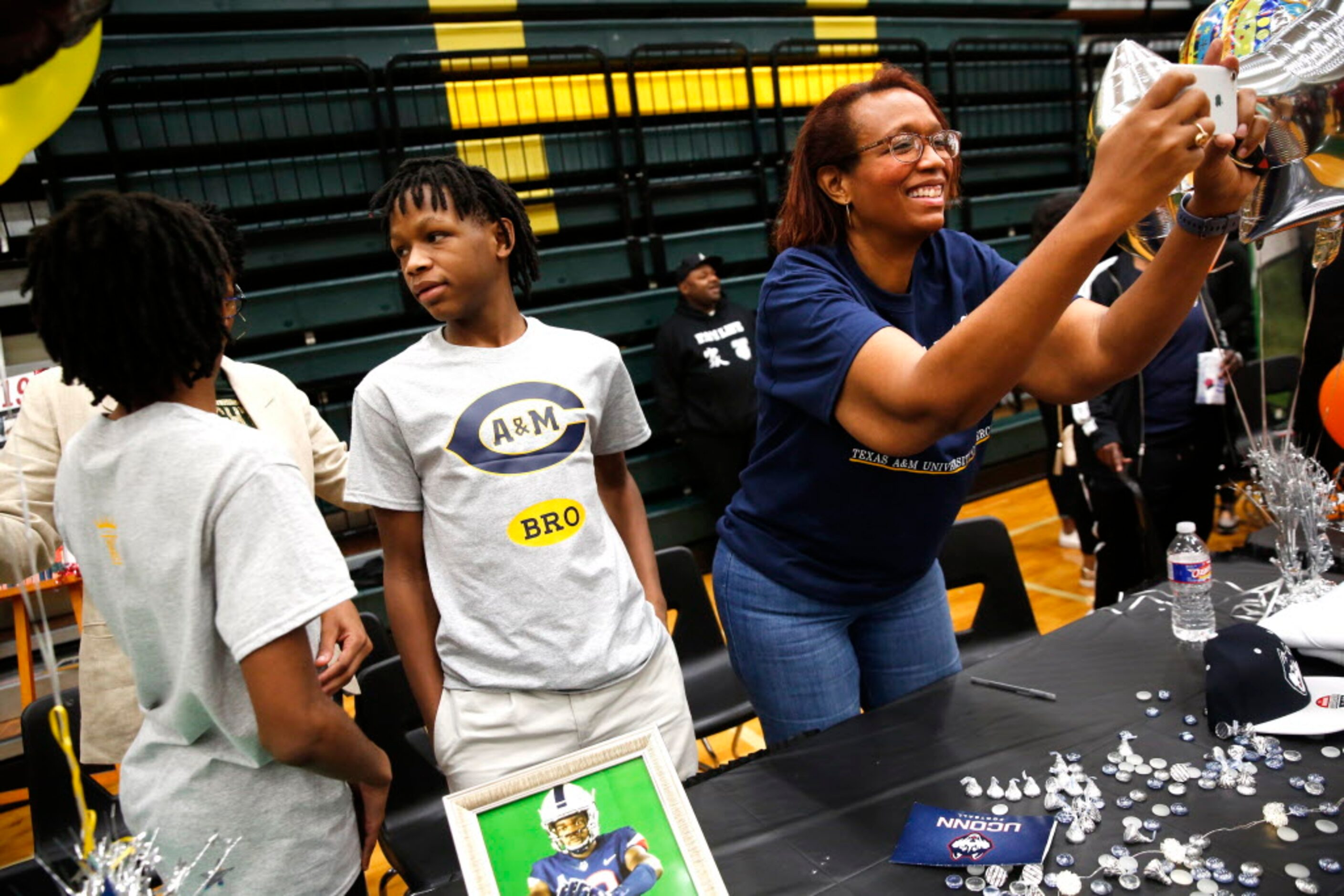 Lori Mathis, mother of safety Champ Mathis who signed with Texas A&M Commerce, takes a photo...