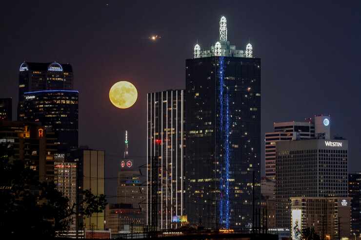 The blue supermoon, the second supermoon of August, rises behind the Dallas skyline on...