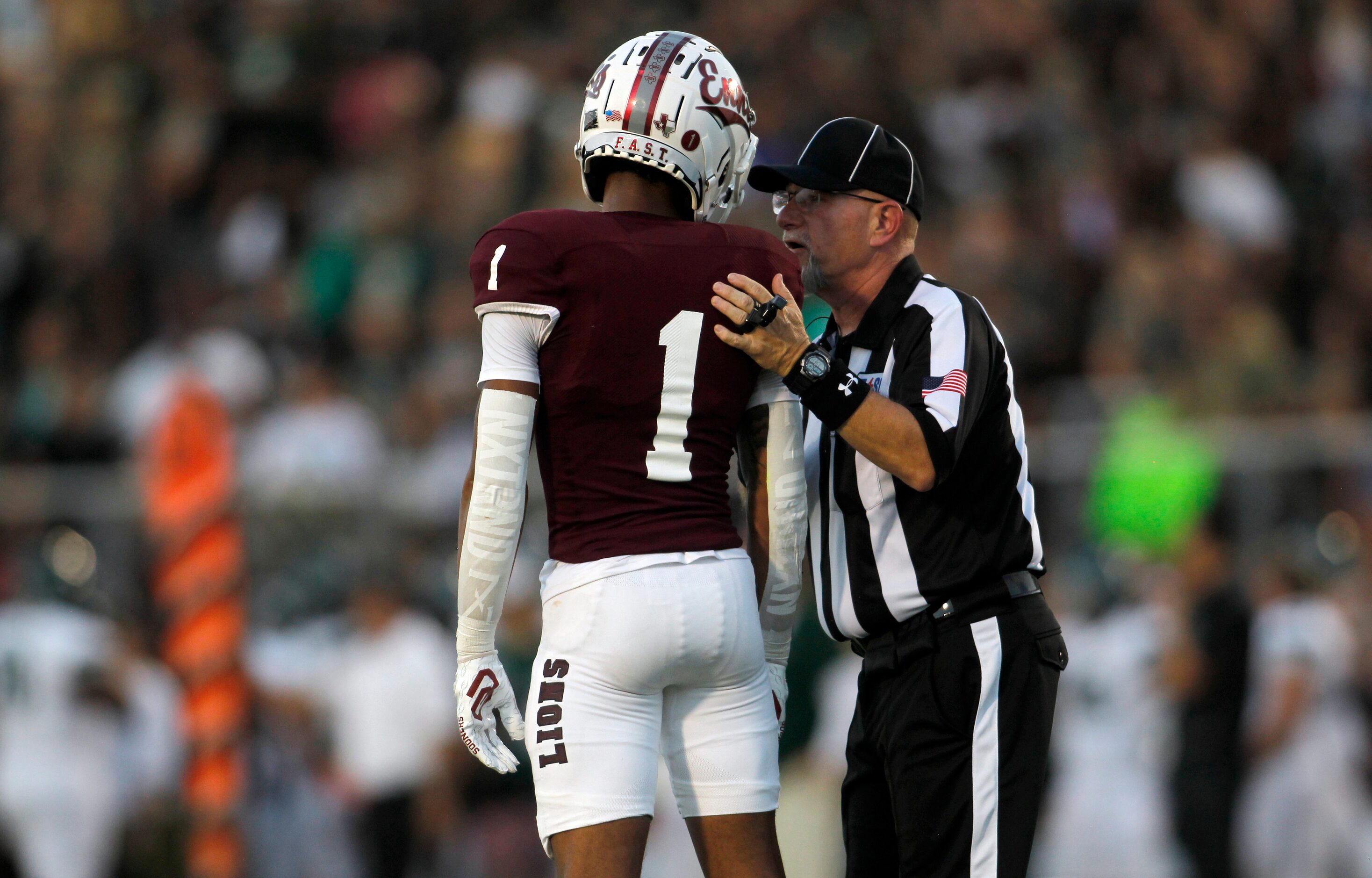 A game official has a word with Ennis punt returner prior to returning a first quarter punt...