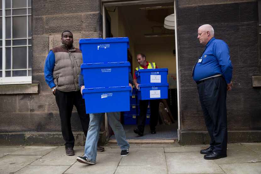 Scottish independence referendum ballot boxes are carried to be loaded onto vans to be...