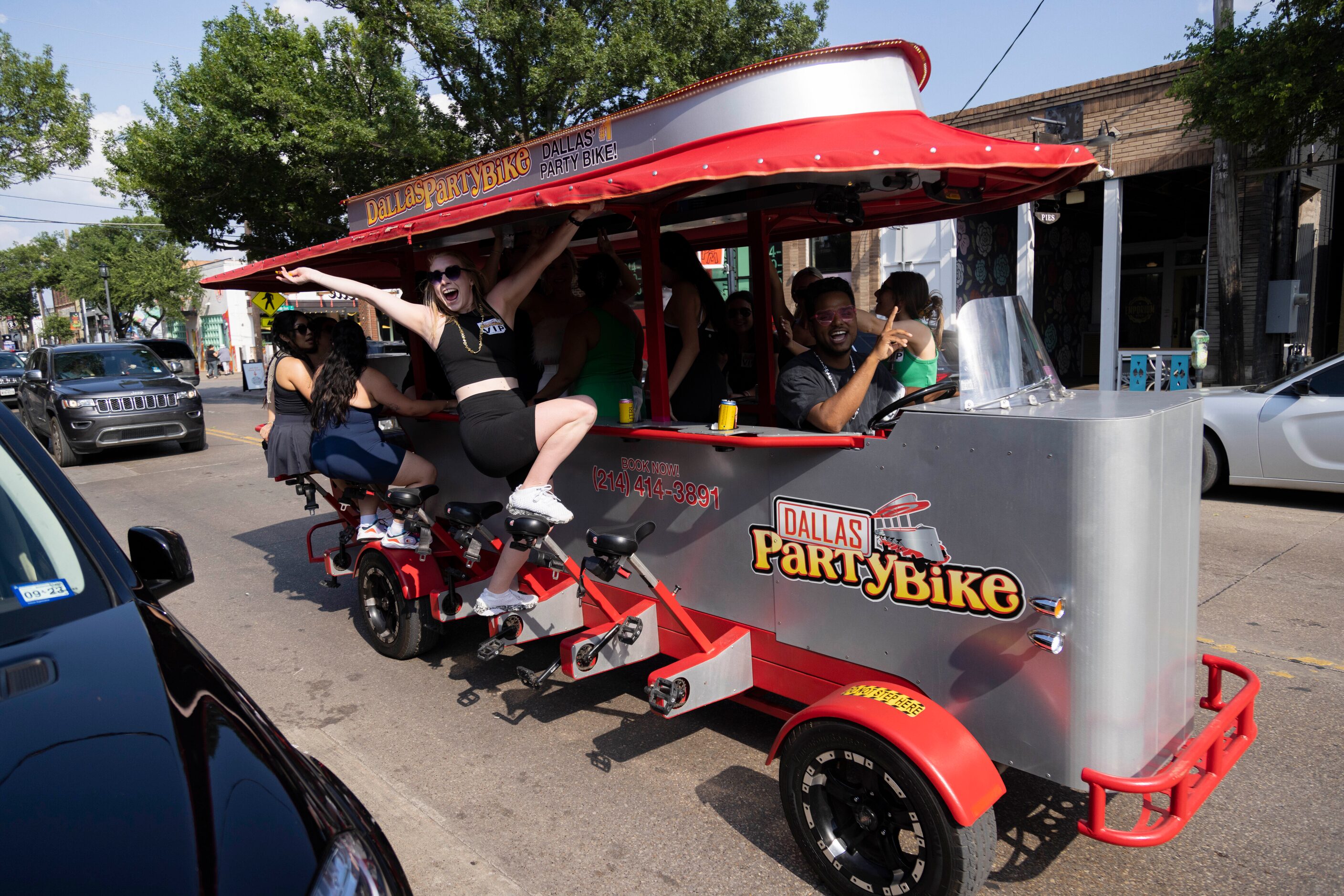 People celebrate while on a Dallas Party Bike going through Main Street in the Deep Ellum...