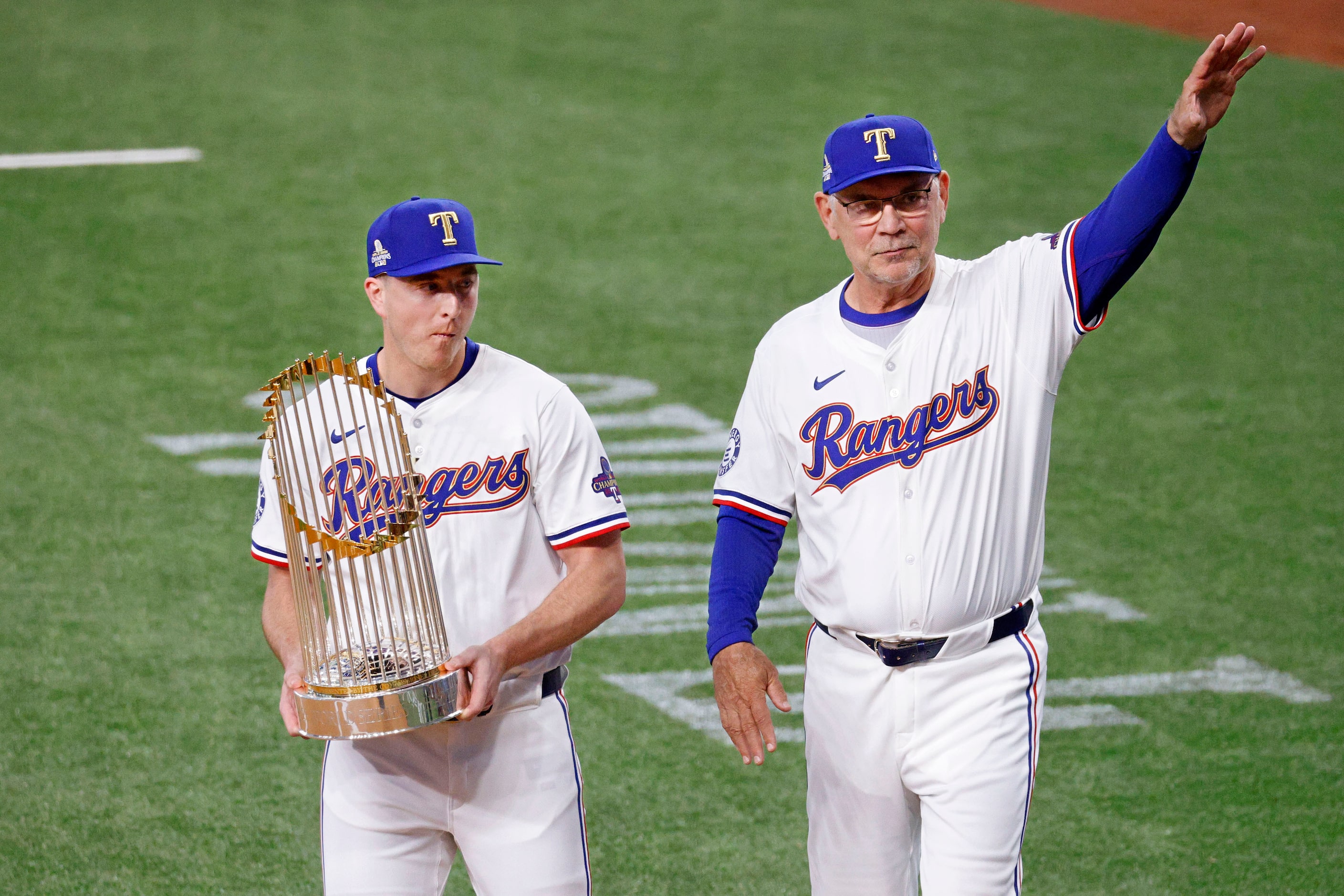 Texas Rangers manager Bruce Bochy waves as Texas Rangers pitcher Josh Sborz (66) holds The...