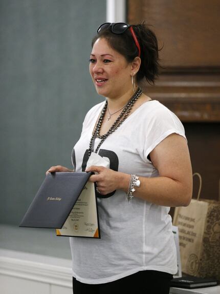 Wendy Birdsall, 41, holds up her diploma from El Centro College while talking to Celanese...