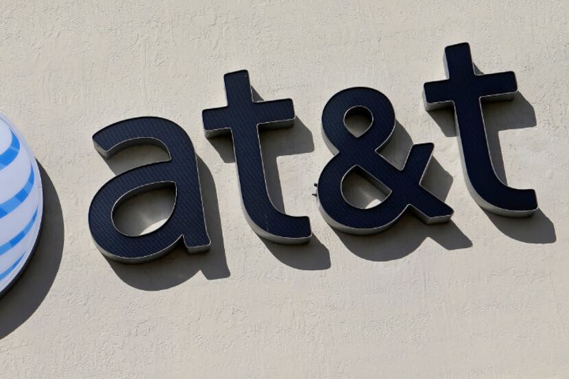 A file photo shows the AT&T sign at a store in Hialeah, Fla. Some 17,000 AT&T workers in...