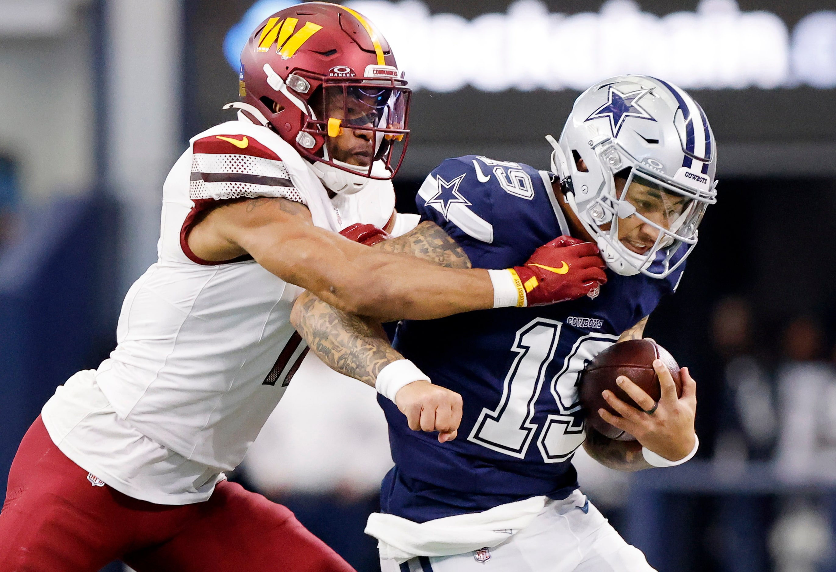 Dallas Cowboys quarterback Trey Lance (19) is driven out of bounds by Washington Commanders...