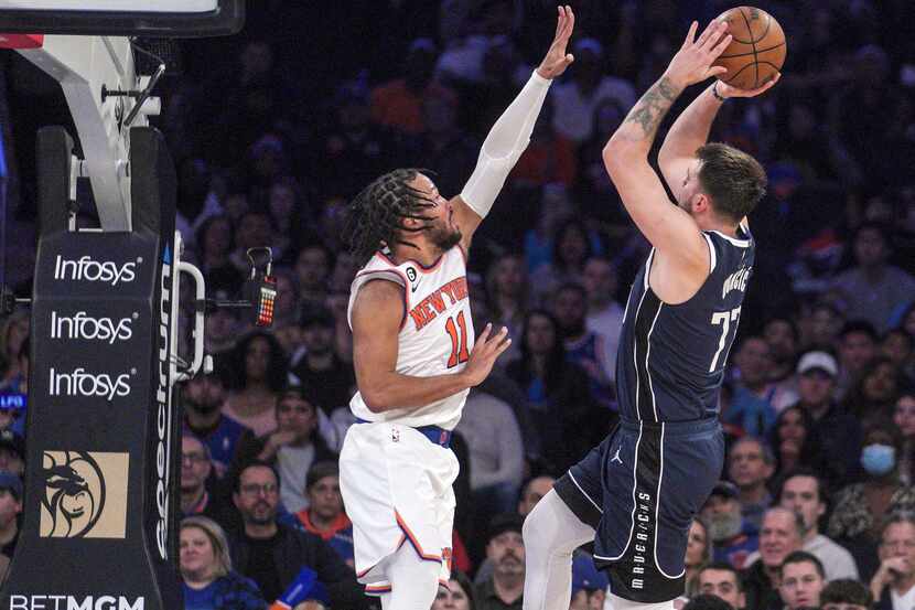 Dallas Mavericks guard Luka Doncic, right, shoots over New York Knicks guard Jalen Brunson,...