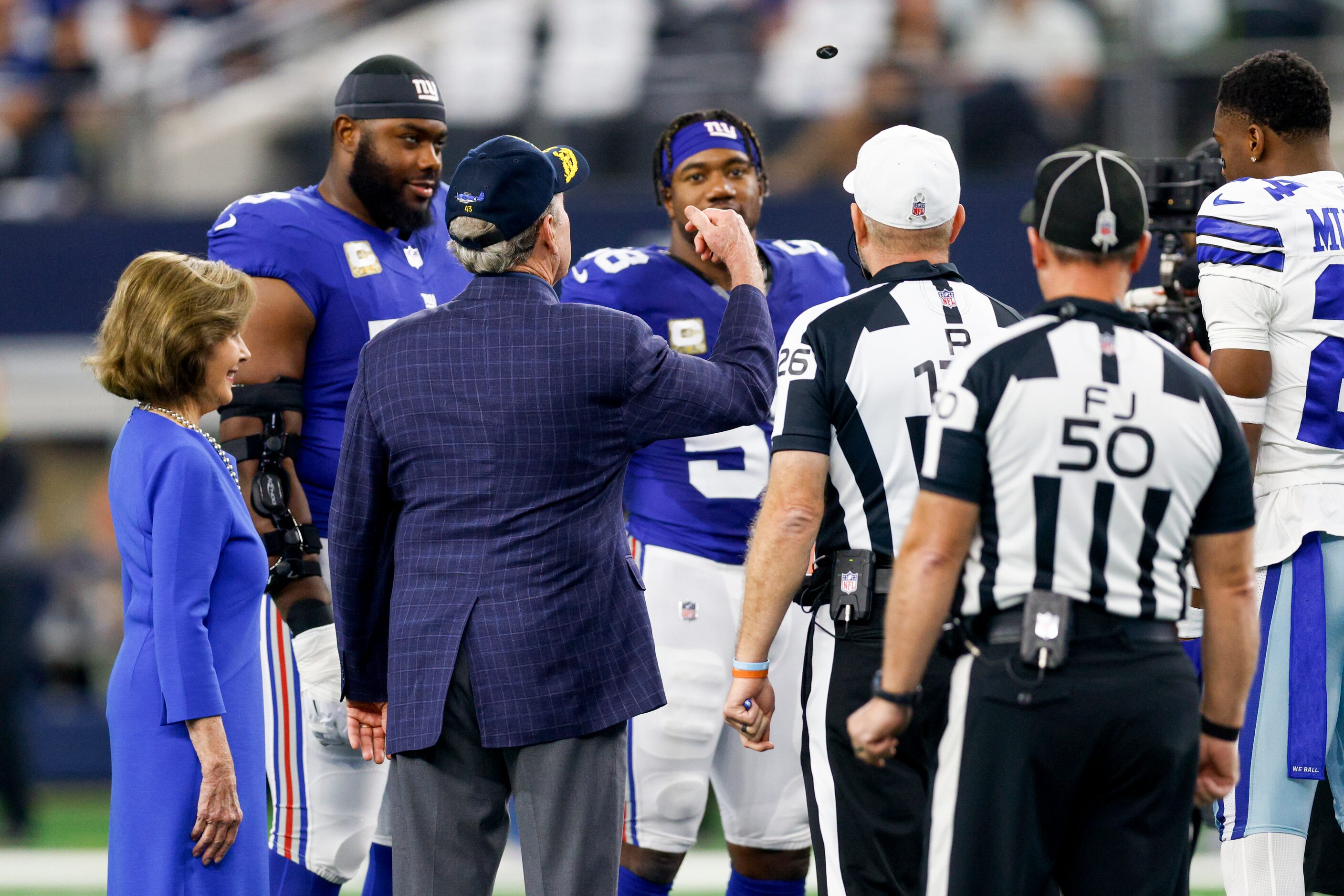 Former President George W. Bush performs the coin toss before an NFL game between the Dallas...