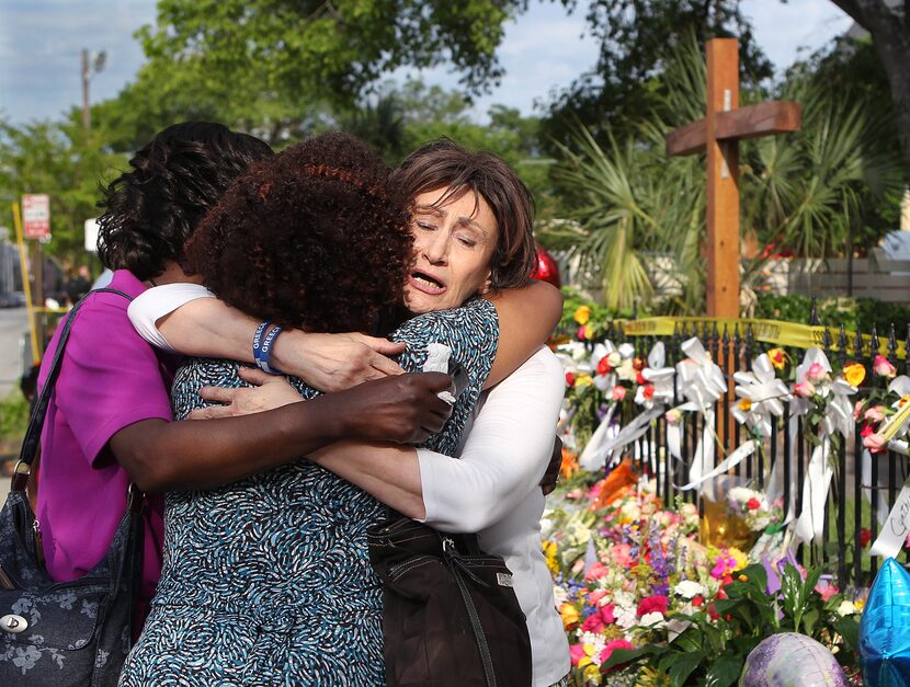 From left, Patricia Bailey, Carol Reid and Maria Bornhorst console each other as Bornhorst...