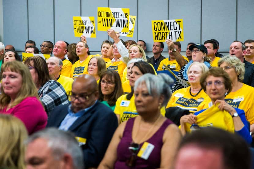 Cotton Belt supporters hold up signs as the board of the Dallas Area Rapid Transit voted to...