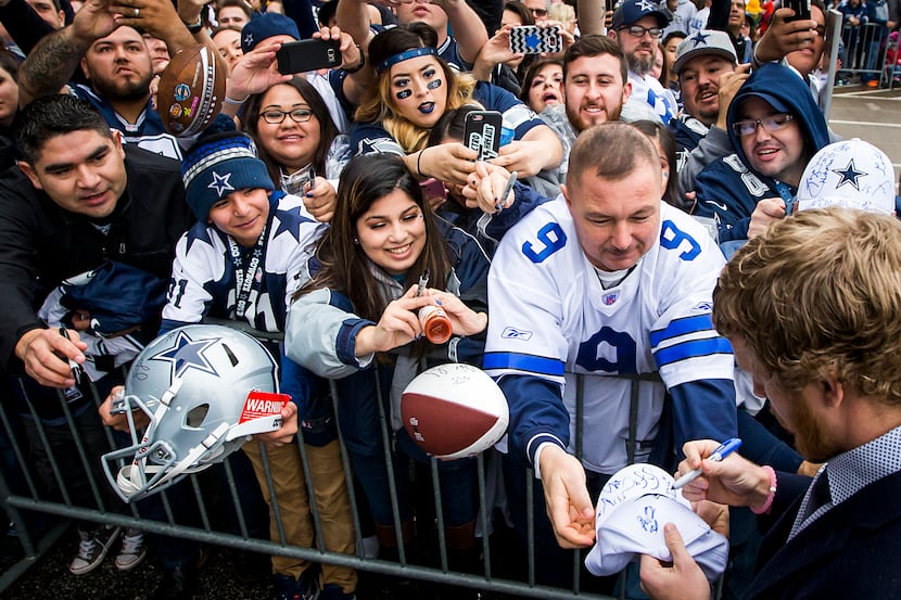 Dallas Cowboys wide receiver Cole Beasley signs autographs for fans as he arrives at the...