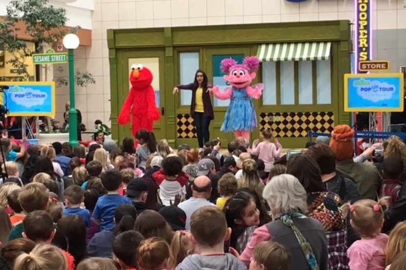 From left to right: Elmo, Dani, and Abby Cadabby do the "Happy Dance" while teaching about...