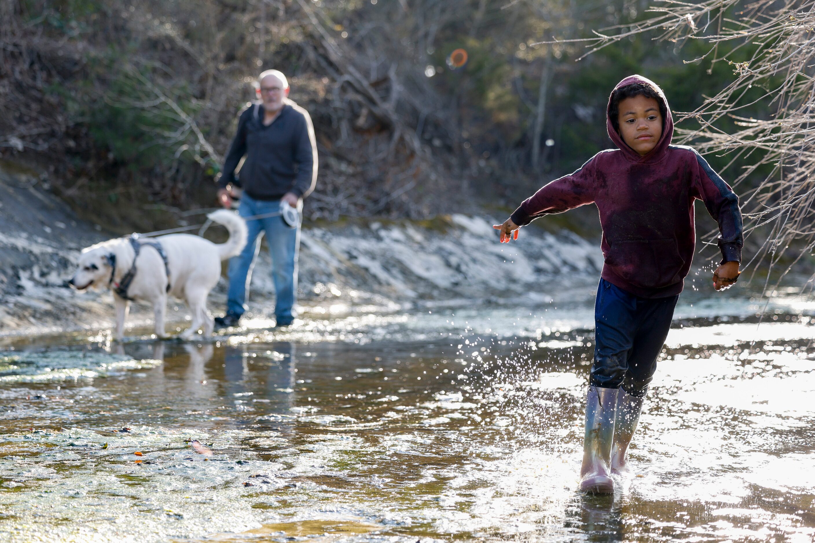 Judah Koontz, 5, splashes through Tenmile Creek on the Ladd property in Duncanville, Texas,...