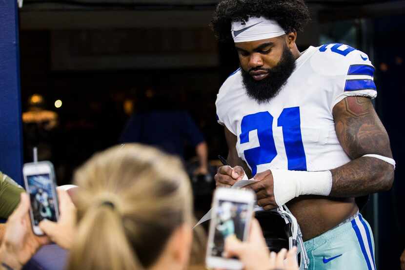 Dallas Cowboys running back Ezekiel Elliott (21) signs autographs for fans before an NFL...