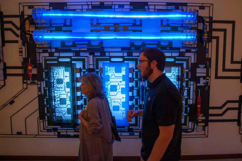 Guests stroll past a portion of the triptych art installation “Motherboard” in the Green...
