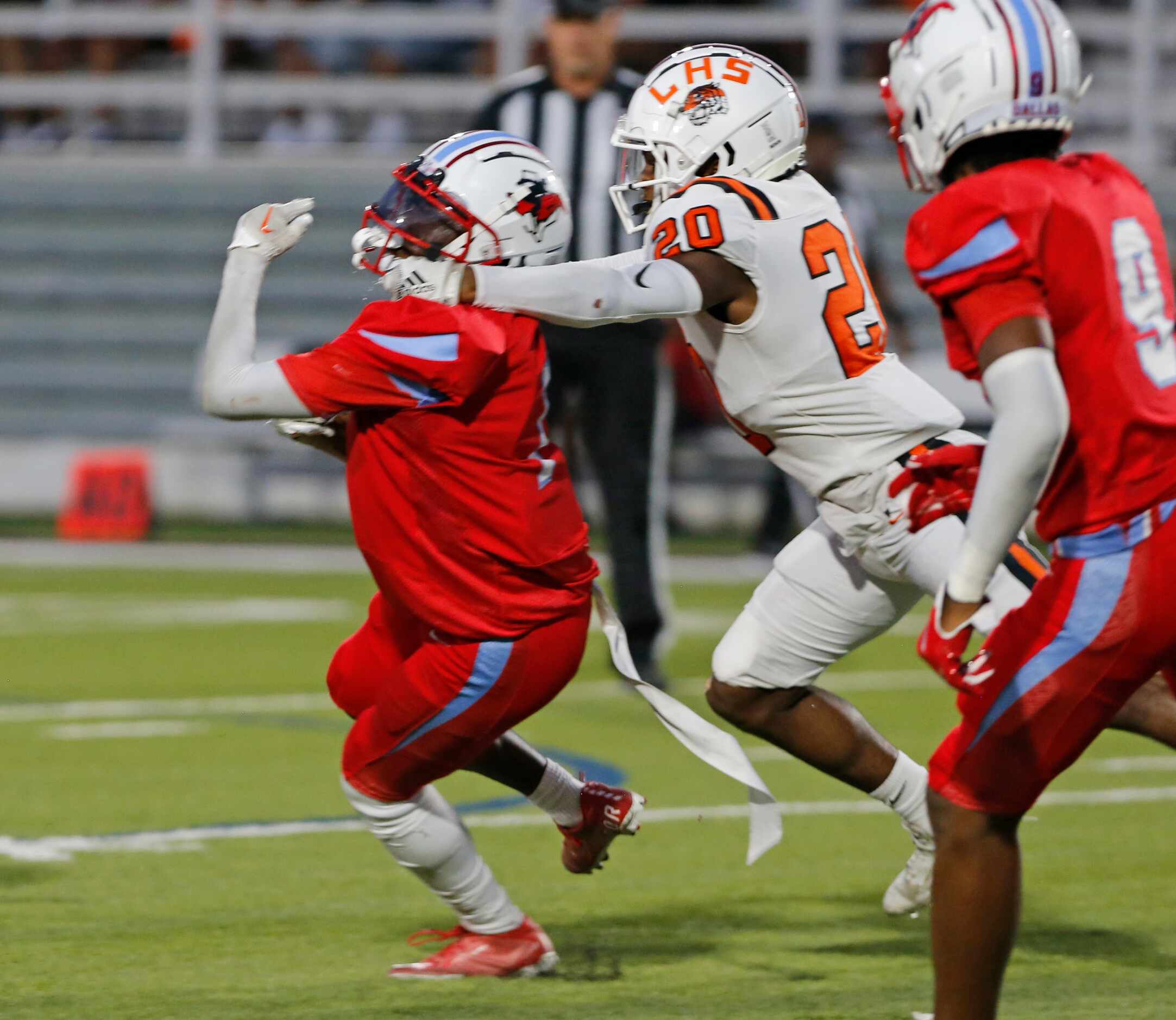 Skyline High’s Jainel Lewis (7) has his helmet grabbed by Lancaster High’s Romel Tipton (20)...