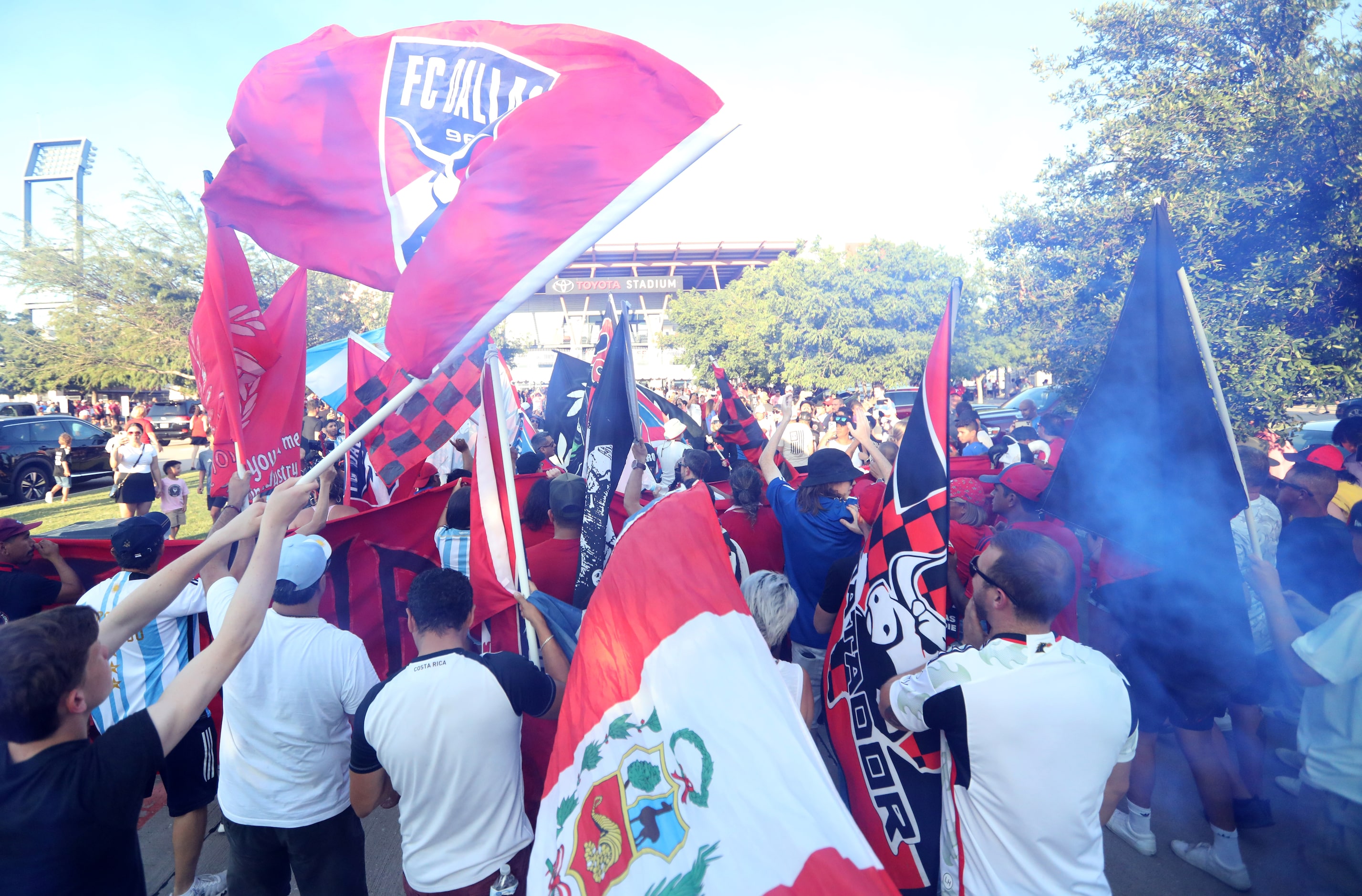 Fans join a parade as the gates to open for an FC Dallas game at Toyota Stadium in Frisco,...