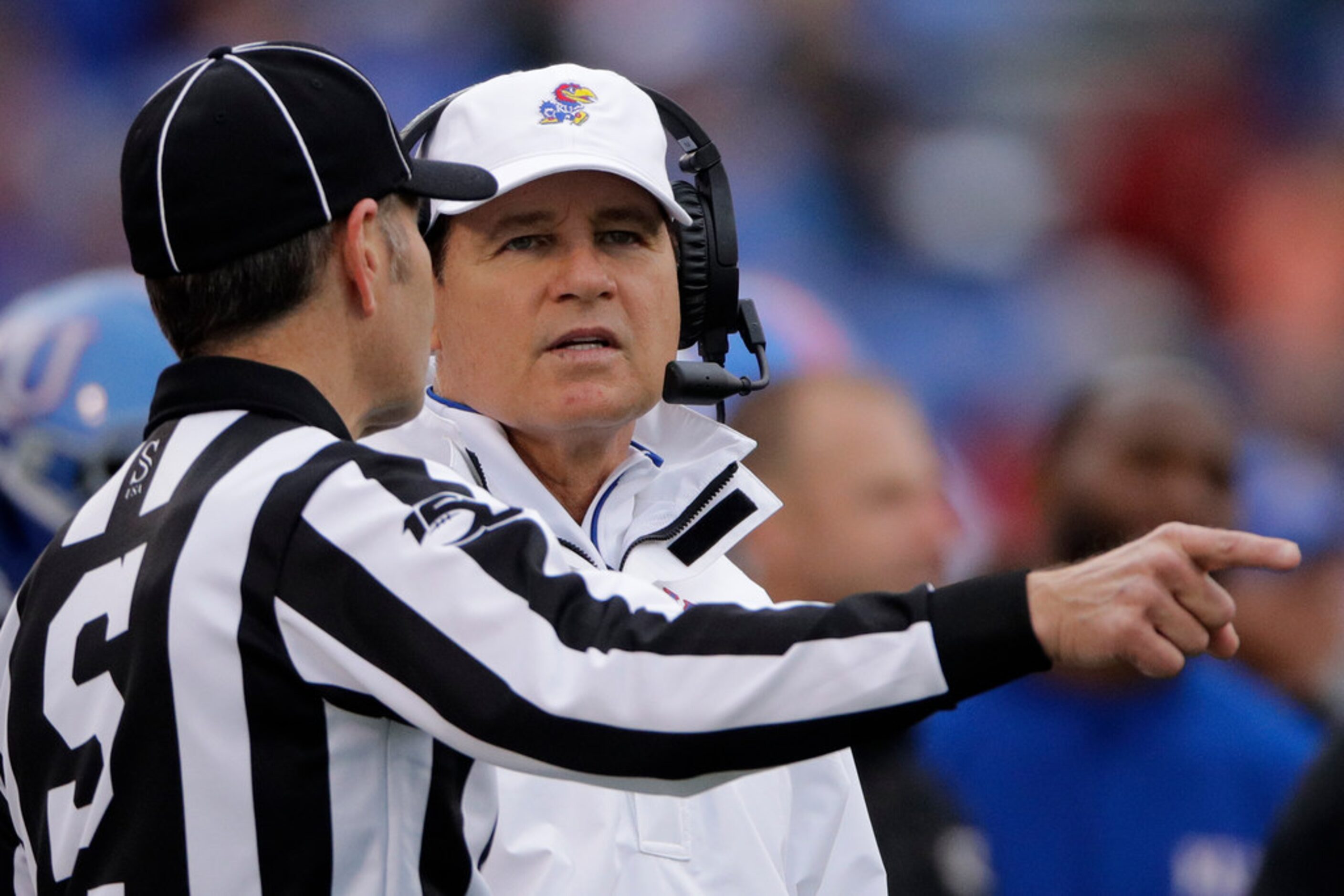 Kansas head coach Les Miles talks to an official during the first half of an NCAA college...