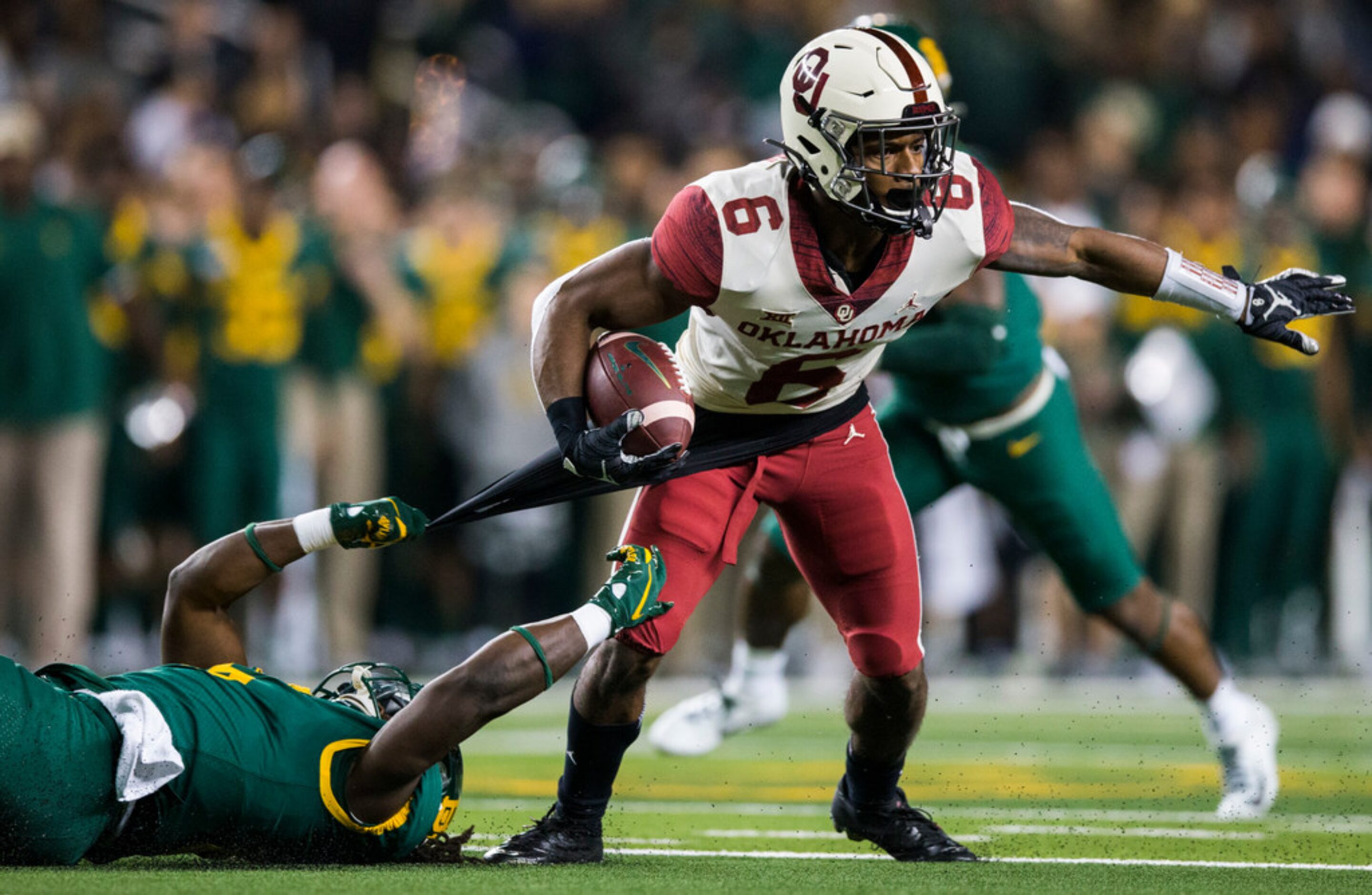 Baylor Bears running back JaMycal Hasty (6) tackles Oklahoma Sooners cornerback Tre Brown...