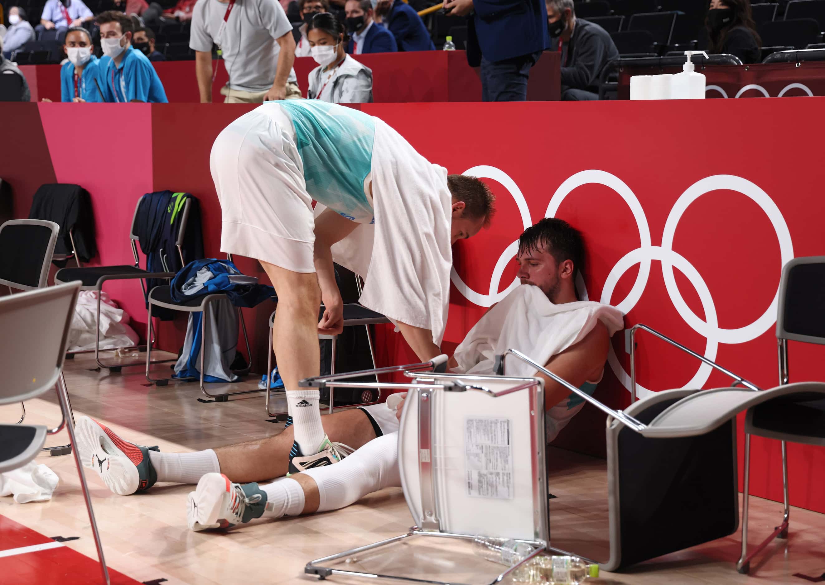 Slovenia’s Luka Doncic (77) sits dejected as teammate Klemen Prepelic (7) talks to him after...