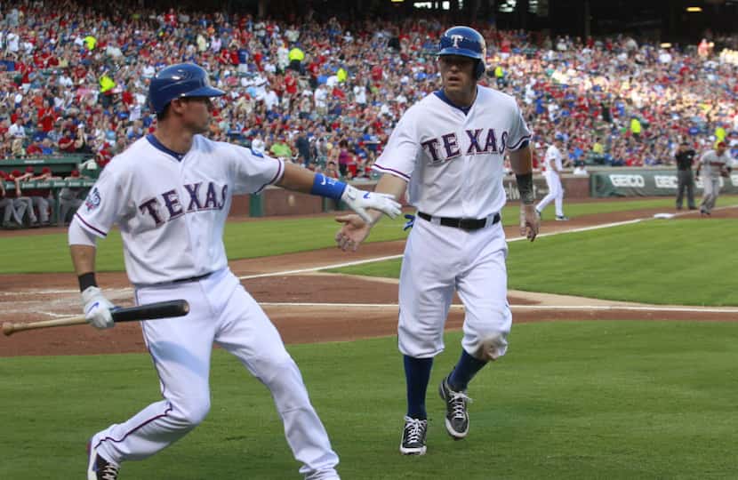 FILE - Texas Rangers designated hitter Michael Young (10) congratulates Ian Kinsler after he...