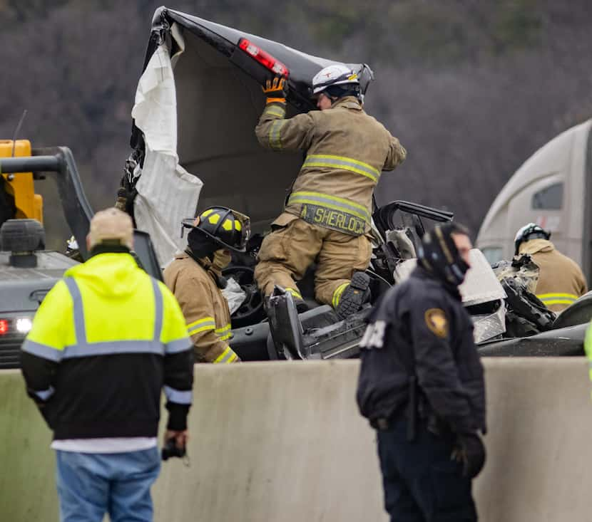 Emergency crews work to clear the mass casualty pile-up on I-35W and Northside Drive in Fort...