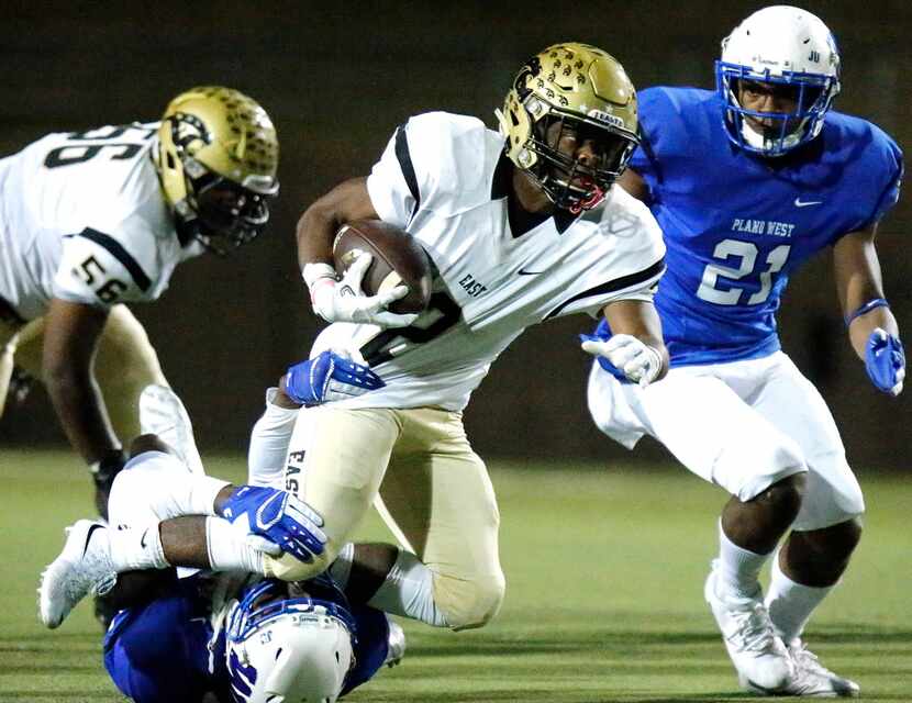 Plano East High School running back Jonathan Meadors (2) is brought down by Plano West High...