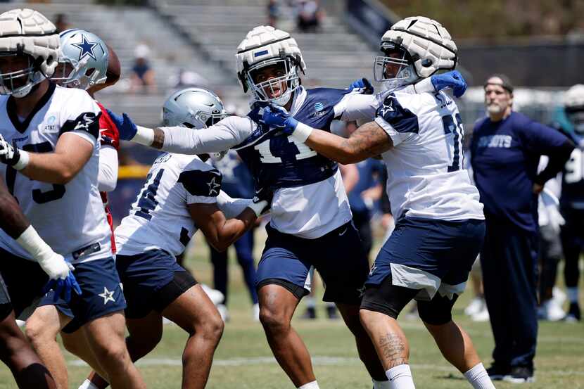 Dallas Cowboys outside linebacker Micah Parsons (11) fights off offensive lineman as he...