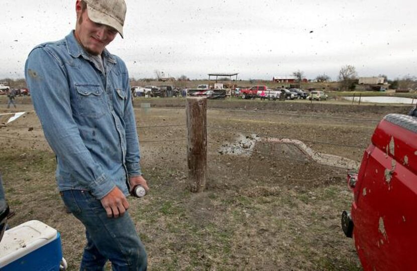 
Andrew Wood of McKinney turns away as mud from a racing truck flies in his direction. 
