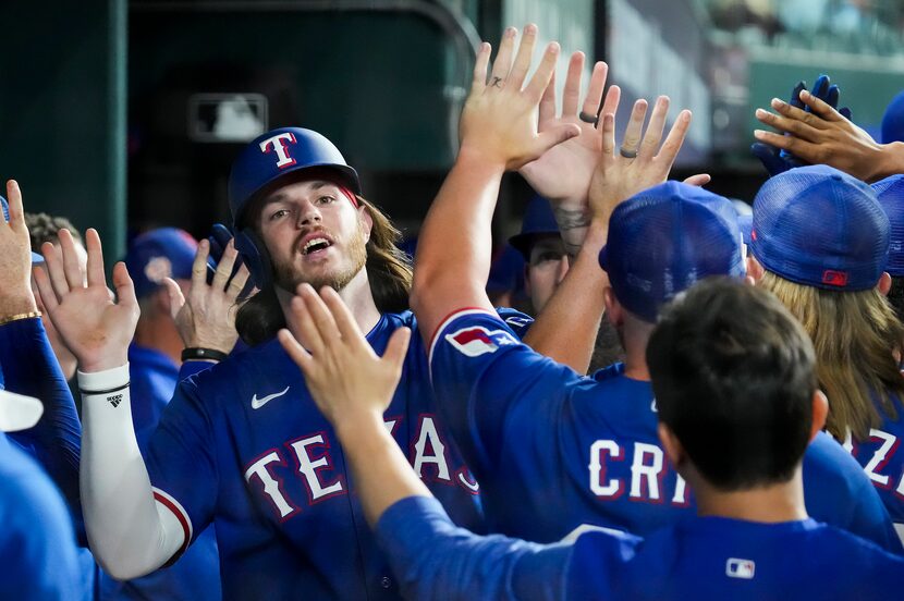 Texas Rangers designated hitter Jonah Heim celebrates after scoring on a double by Josh...