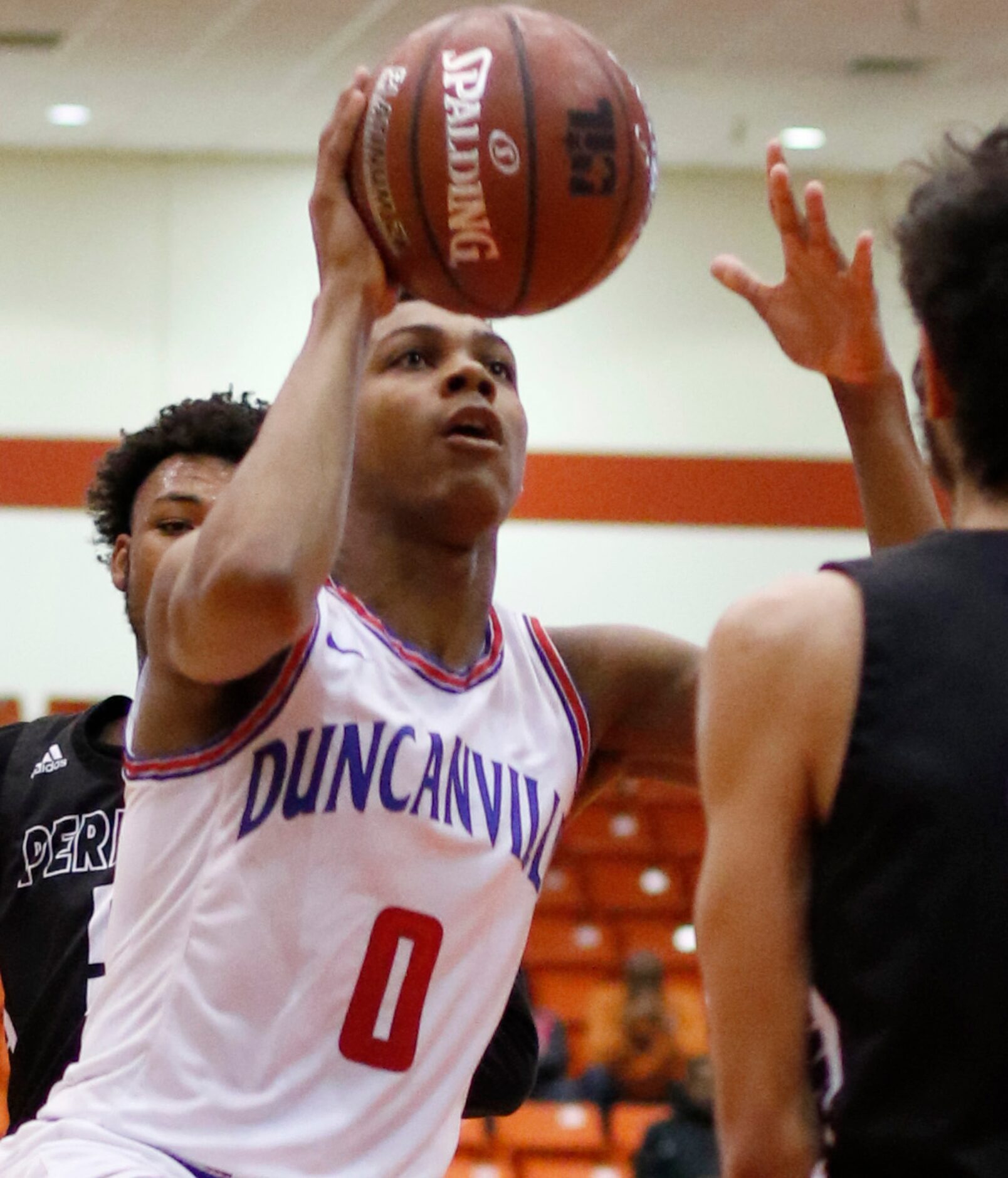 Duncanville guard Zhuric Phelps (0) drives the lane splitting two Odessa Permian defenders...