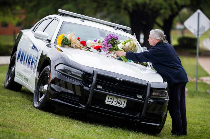 Marcia Niemann placed flowers on a Dallas police car in honor of Officer Rogelio Santander...