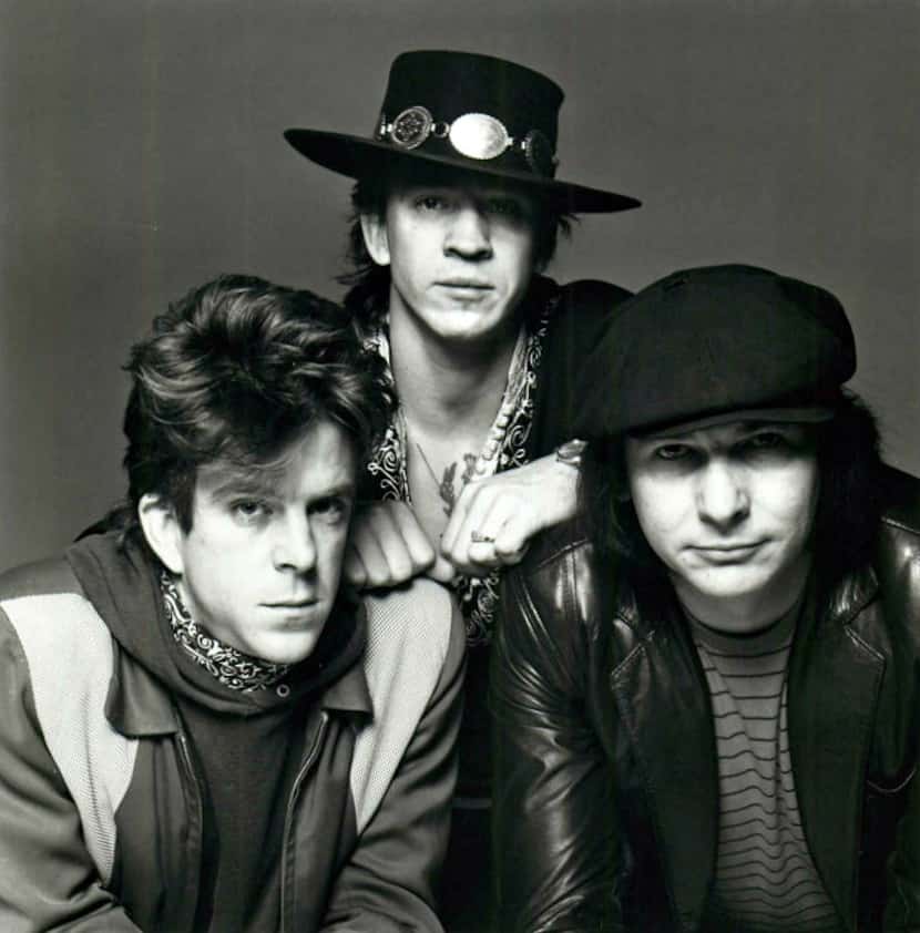 Chris Layton and Tommy Shannon flank Stevie Ray Vaughan in an early Epic Records Double...