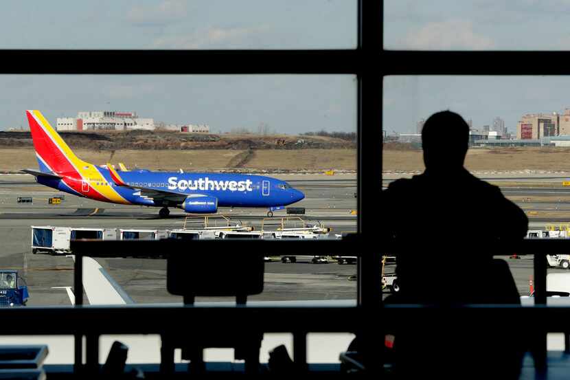 In this Jan. 25, 2019, file photo a Southwest Airlines jet moves on the runway as a person...