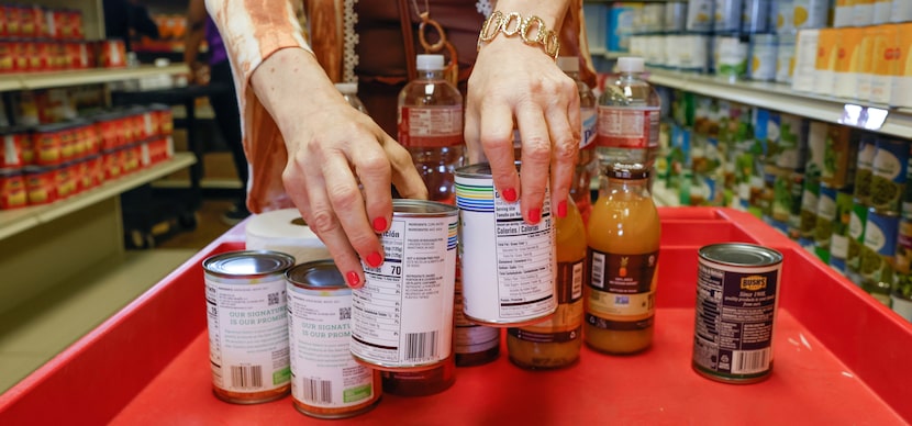 Dixie Perkins placed canned vegetables in her cart at Community Food Pantry in McKinney on...