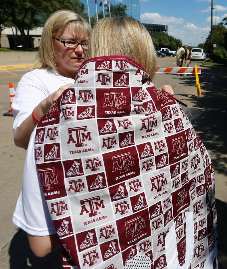Angie Rogers ties a Texas A&M cape onto her daughter, Blair McCurdy, as Blair prepares to...