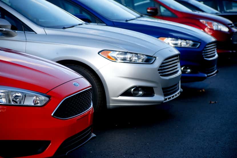 FILE- In this Nov. 19, 2015, photo, a row of new Ford Fusions are for sale on the lot at...