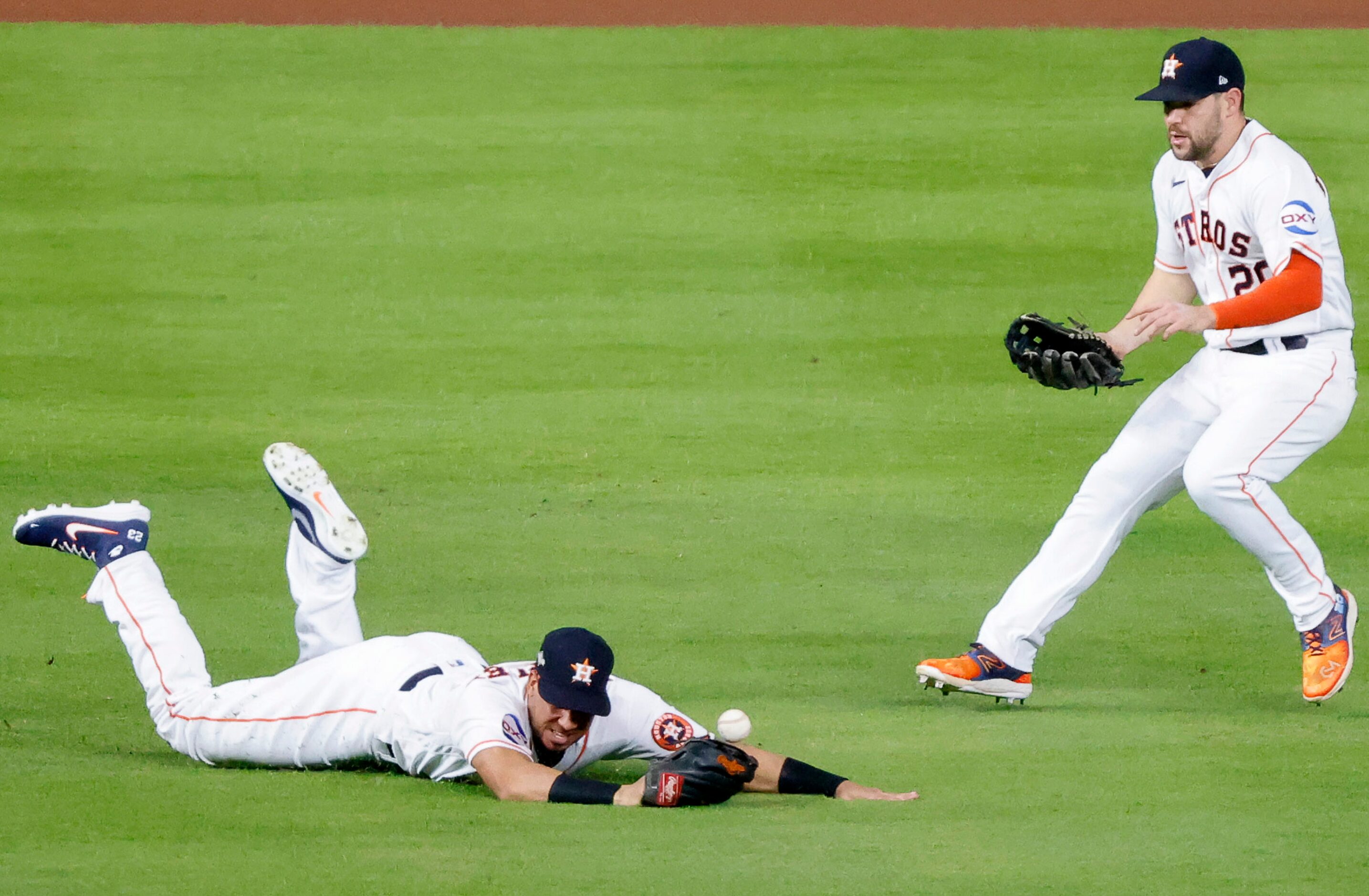 Houston Astros left fielder Michael Brantley (23) misses catching a hit by Texas Rangers...