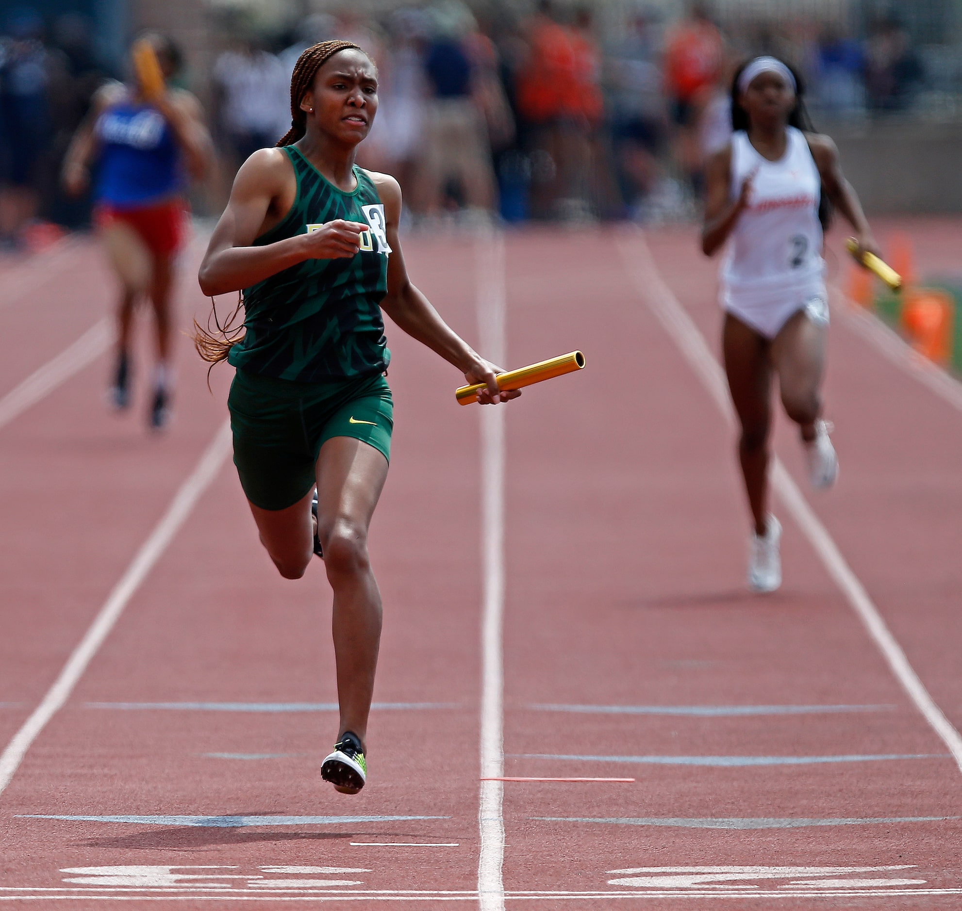 Logan Neely, 17, crosses the finish line first for DeSotto High School in the giles 4x200...