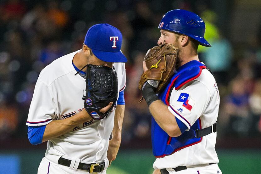 Texas Rangers starting pitcher Cole Hamels gets  visit from catcher Bryan Holaday during the...