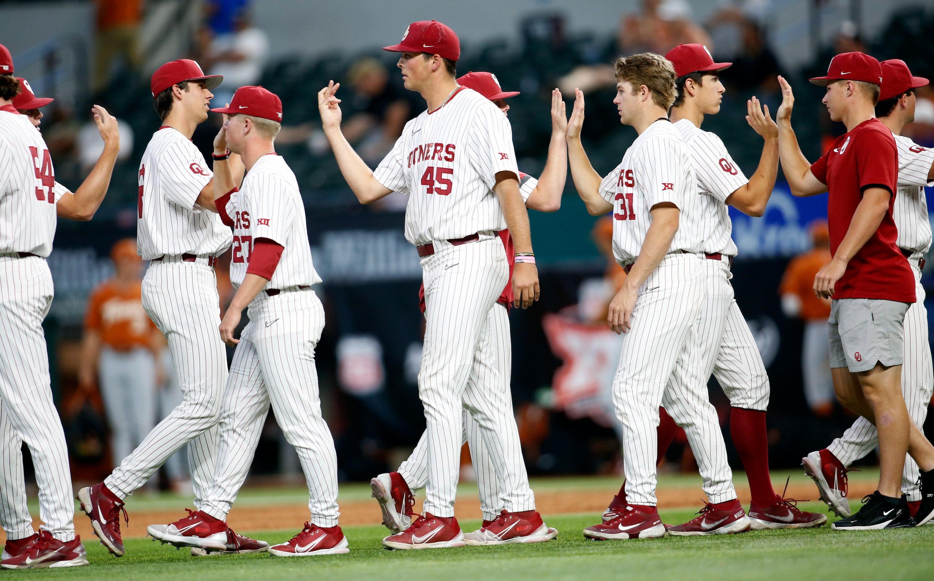 Oklahoma Sooners players congratulate each other on the field following their 4-3 victory...