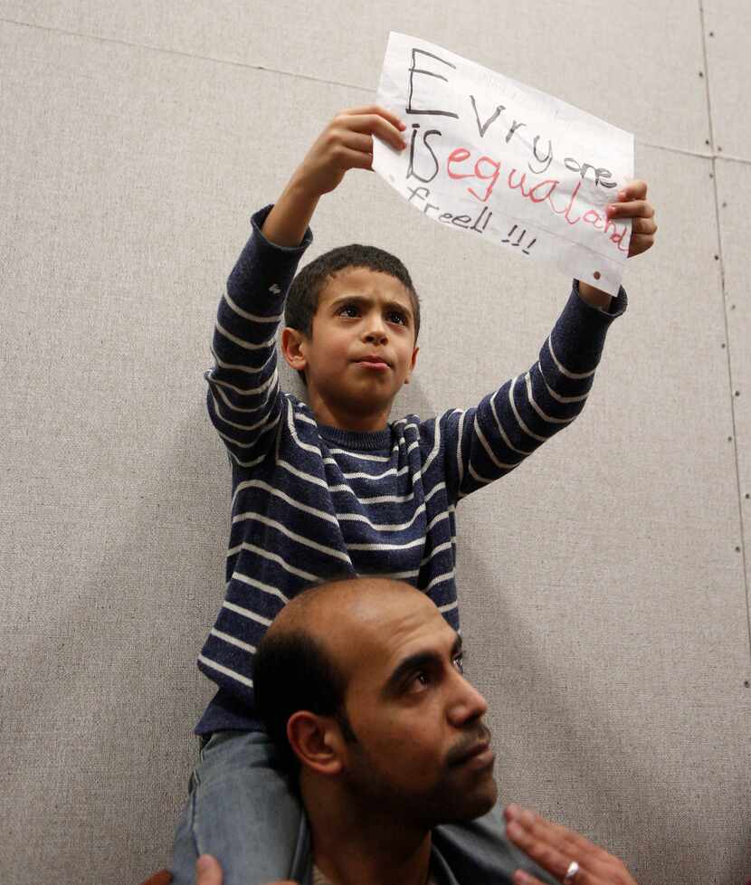Mahmoud and his son Nour, 7, join the protest to denounce President Donald Trump's executive...