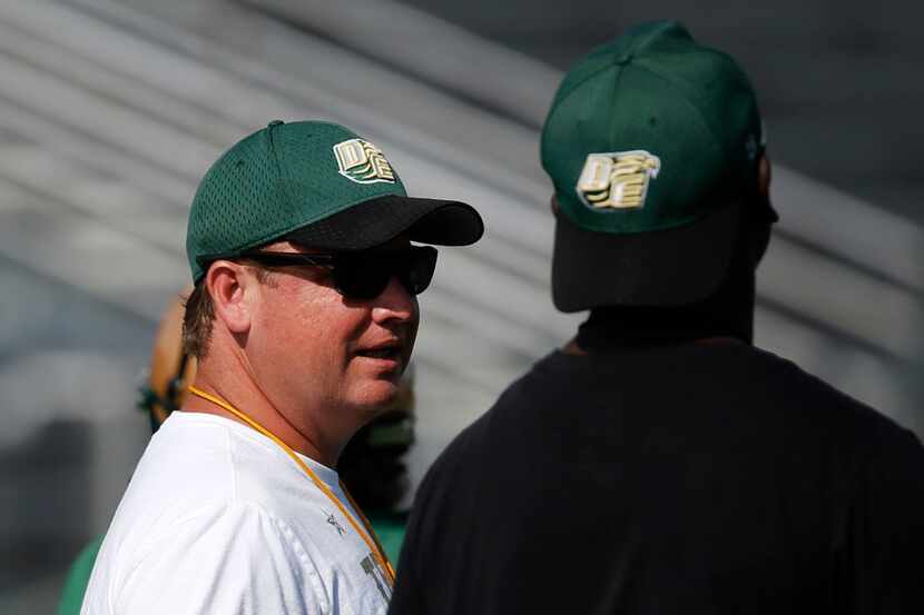 DeSoto head football coach Todd Peterman (left) talks to coaching staff during spring...