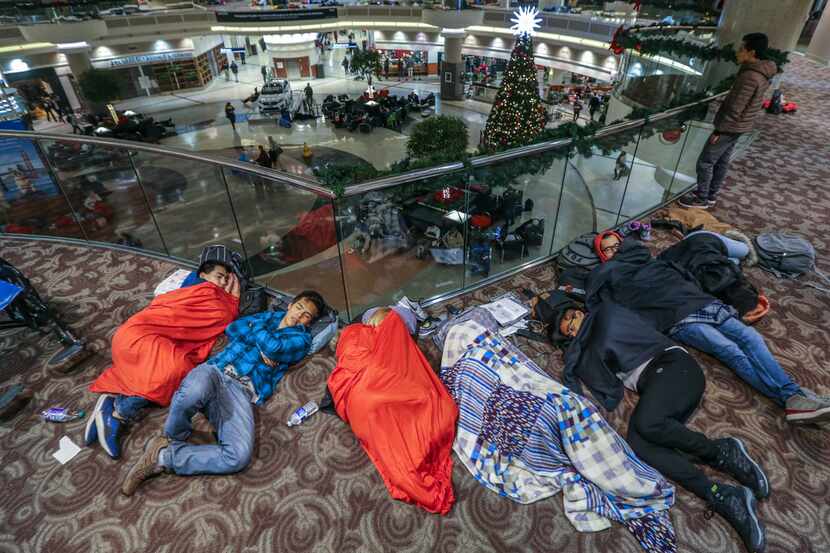 Travelers slept in the atrium at Hartsfield-Jackson International Airport on Monday, the day...