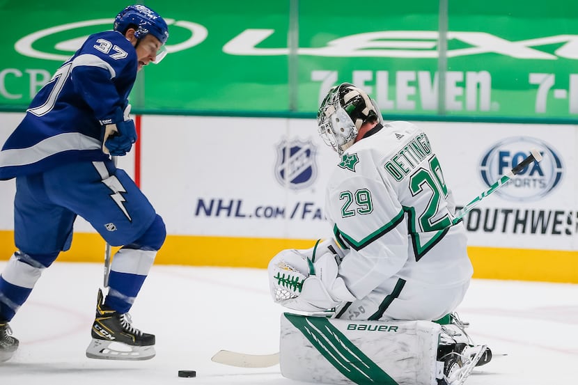 Dallas Stars goaltender Jake Oettinger (29) stops a shot from Tampa Bay Lightning forward...